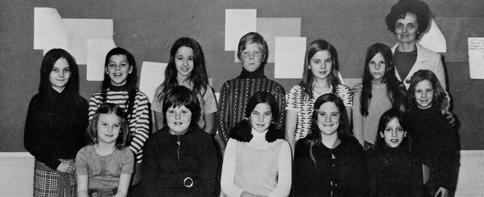 Black and white photograph of Groveton Elementary School's Library Committee from the 1972 to 1973 yearbook. 12 children and one adult are pictured.