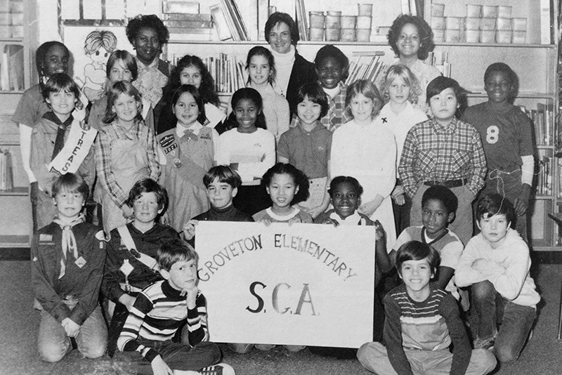 Black and white photograph of Groveton Elementary School's Student Council from the 1980 to 1981 yearbook. 23 children and three adults are pictured. Three students are holding up a sign that reads Groveton Elementary SCA.